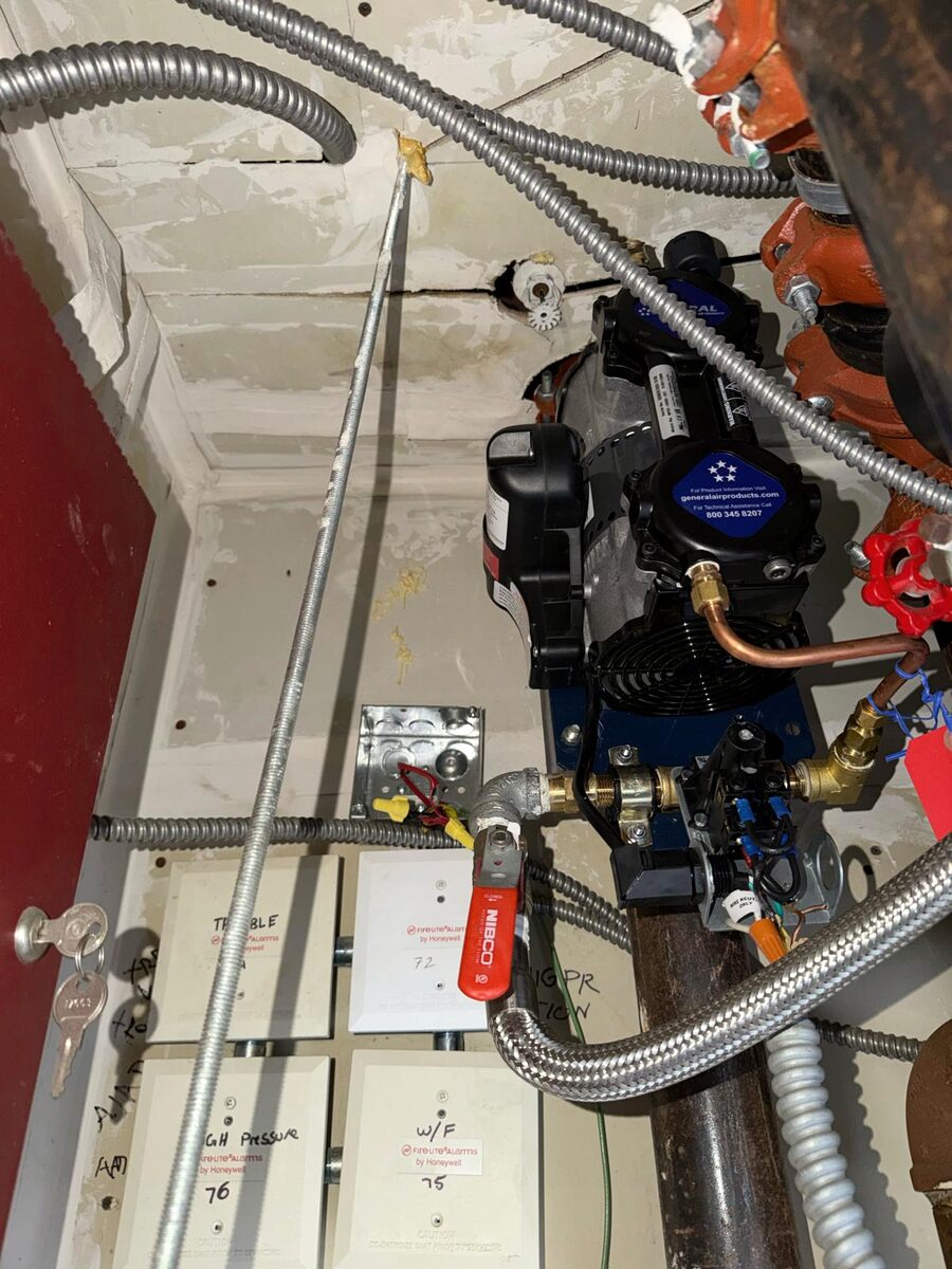 New 1/3 HP oil-less air compressor installed on an apartment building's dry-pipe fire-sprinkler riser after Paragon's same-day replacement