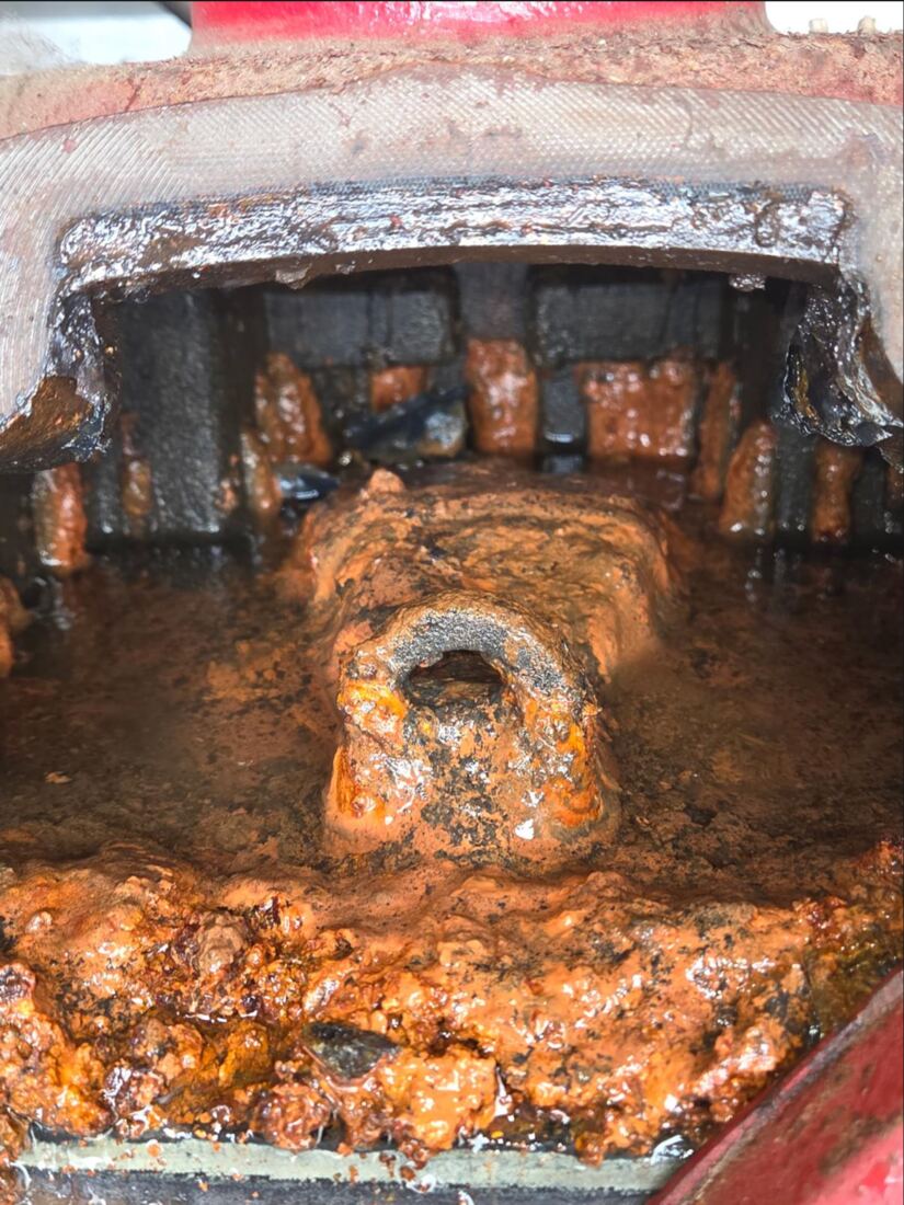 The interior of a dry-pipe valve caked with rust and scale, found during a five-year internal inspection