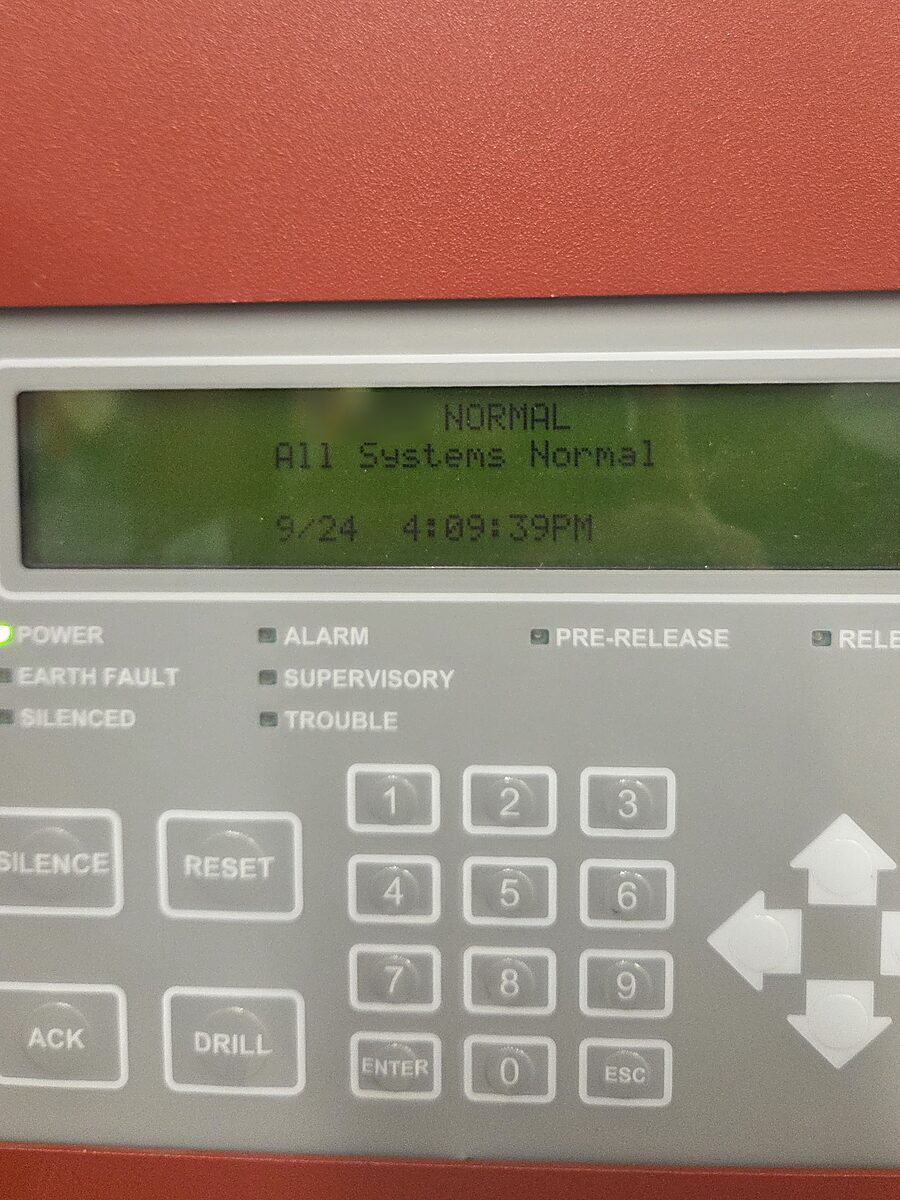Fire alarm panel display reading All Systems Normal