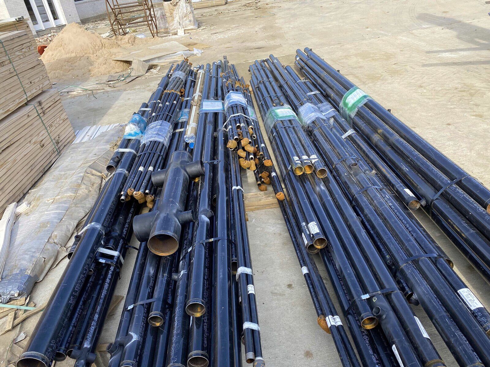 Black-steel sprinkler pipe staged and ready to hang